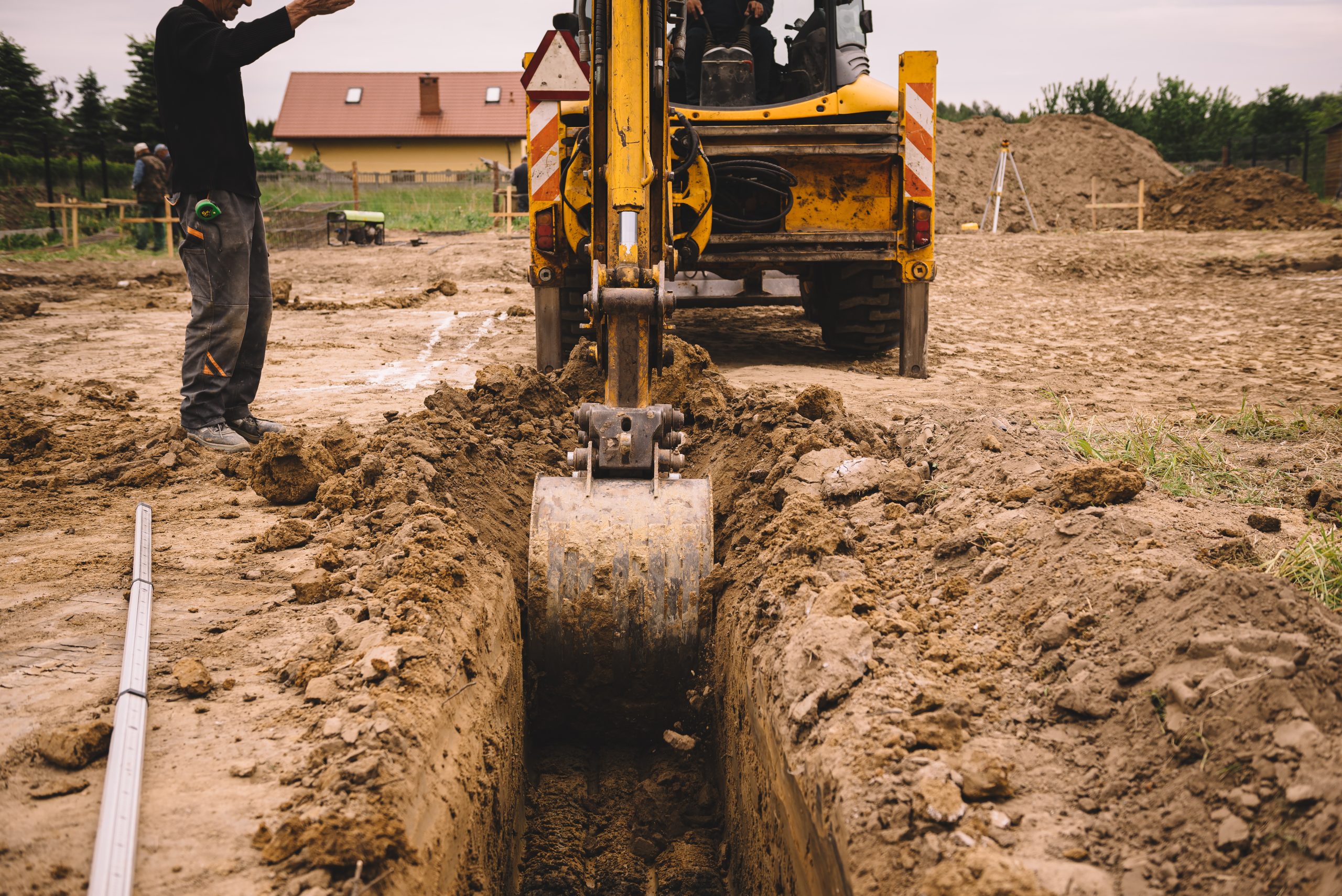 Excavator at house construction site - digging foundations for modern house